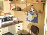 de nombreux chapeaux accrochés au mur au-dessus d'un bureau dans une pièce