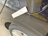 a sticker on the door of a car that is parked on the street