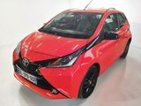 une Toyota AY rouge garée dans une pièce au sol blanc