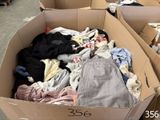 une boîte en carton remplie de vêtements dans une pièce