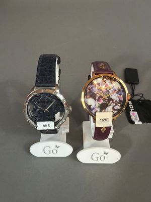 trois montres sont exposées sur un présentoir, accompagnées d'étiquettes