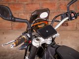 a close up of a motorcycle handlebar with a brick wall in the background