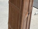 a tall wooden cabinet in the middle of a warehouse floor