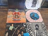 a lot of records sitting on a wooden table