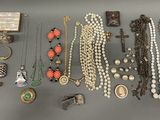 many different types of necklaces and bracelets laid out on a table