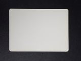 a close up of a white mouse pad on a black surface