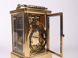 a small gold clock with a glass case on it