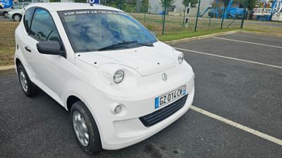 une petite voiture blanche garée dans un parking