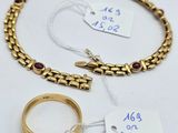 deux bracelets en or et une bague sont posés sur une surface blanche