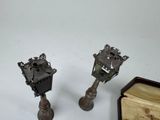 two metal candlesticks sitting next to each other