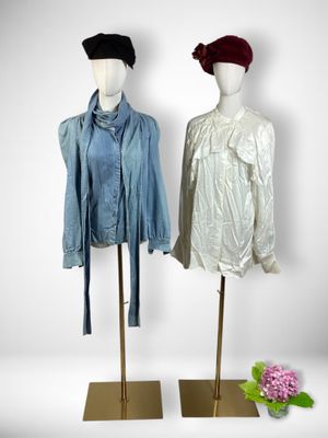 pair of mannequins with jackets and hats on stands