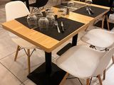 tables and chairs in a restaurant with wooden walls and white tile flooring