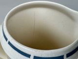 a white and blue bowl with a blue stripe on it