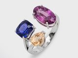 a close up of a ring with two different colored stones