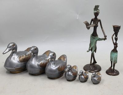 une statue représentant une femme debout à côté d'un groupe de canards