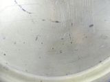 a close up of a metal bowl with a design on it