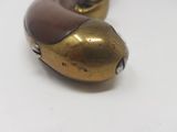 two gold colored metal objects on a white surface