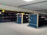 many empty shelves in a store with sodas on them