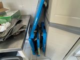 un aspirateur bleu qui se trouve dans un coin de la cuisine