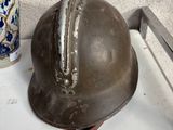 un casque métallique posé sur un plateau à côté d'un vase
