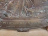 a bronze plaque of a woman in a boat