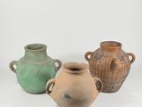 three vases sitting next to each other on a white surface