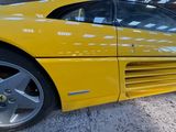 yellow sports car parked in a parking lot with other cars in the background