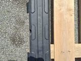 a gun that is sitting on the ground next to a piece of wood