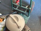 une photo d'un aspirateur posé par terre à côté d'un chariot