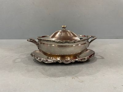 an antique silver plate with a lid and a saucer on it