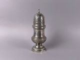 an antique silver salt shaker on a white background