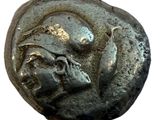 a close up of a coin with a face on it