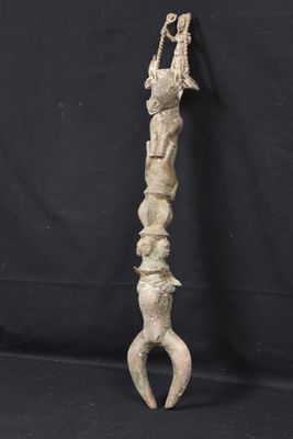 an old wooden sculpture of a person holding a knife