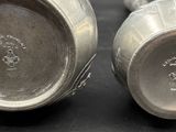two silver vases sitting on top of a table next to each other
