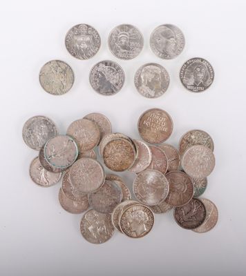 Plusieurs types de pièces de monnaie sont éparpillées sur une surface blanche