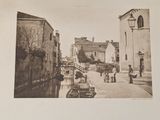 a black and white photo of a street with a bridge