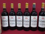 six bottles of wine are lined up in a row on a red background