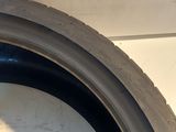 a close up of a tire on a white wall with a black rim