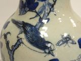 a blue and white vase with a bird on it