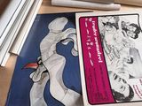 une photo d'un livre posé sur une table, à côté de quelques rouleaux de papier