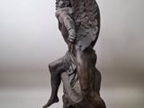 statue of an angel sitting on a rock on a white background