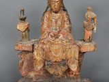 l'image d'une statue de femme assise au sommet d'un rocher