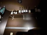bottles of alcohol are lined up on a shelf in a dimly lit room