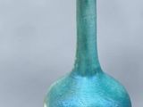 un vase bleu avec une poignée en bois à côté
