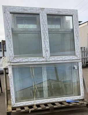 two windows that are on a pallet in front of a building