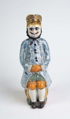 une figurine représentant un homme assis sur une chaise, tenant une citrouille