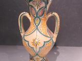 a vase that is sitting on a table with a gray background