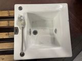 a white sink sitting on a wooden bench next to a metal faucet