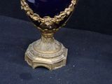 a blue vase with gold decoration on it on a black surface