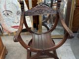 une chaise en bois ornée d'une peinture, placée devant un miroir